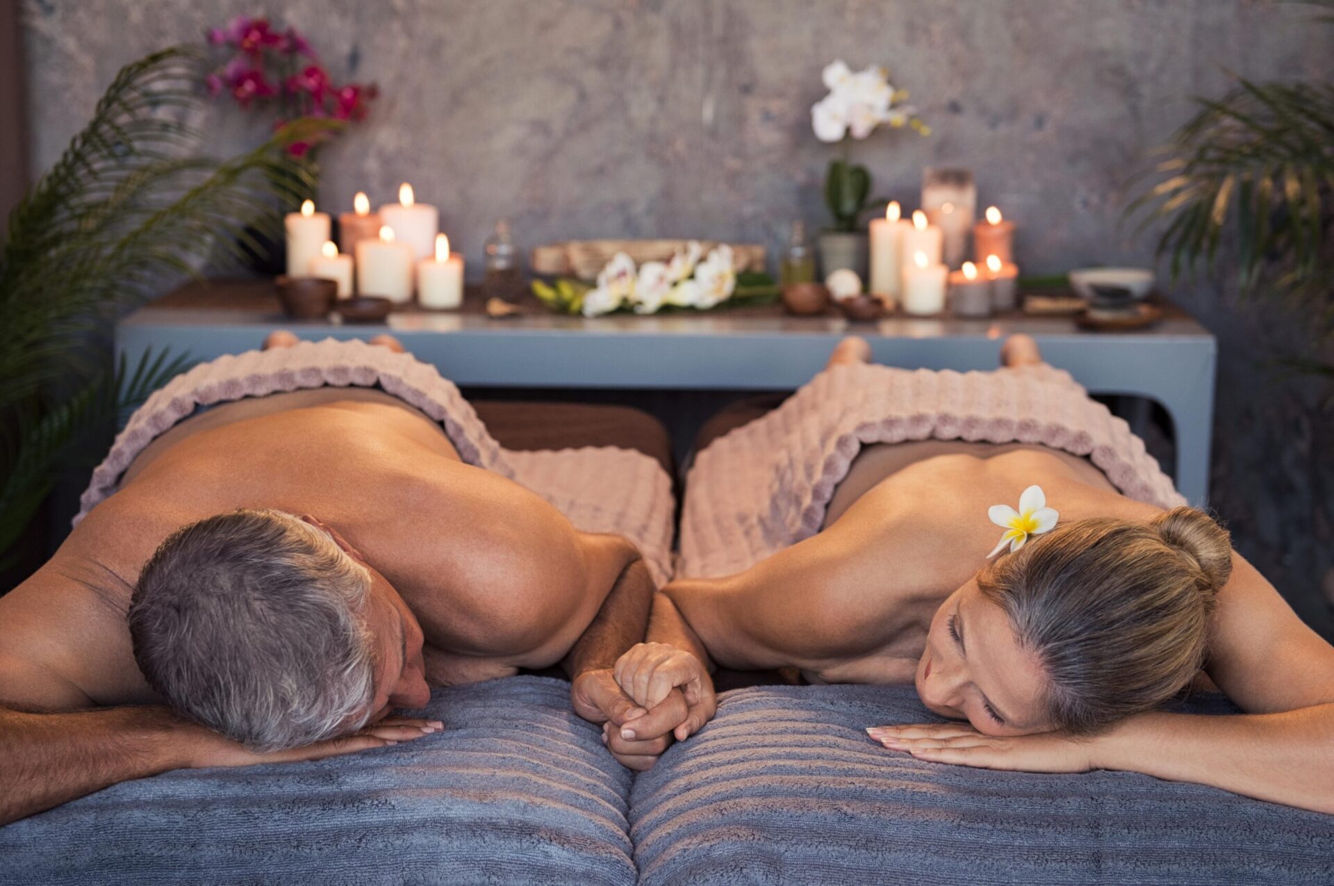 Homme et femme se tenant par la main sur deux lits de massage-Massothérapie.